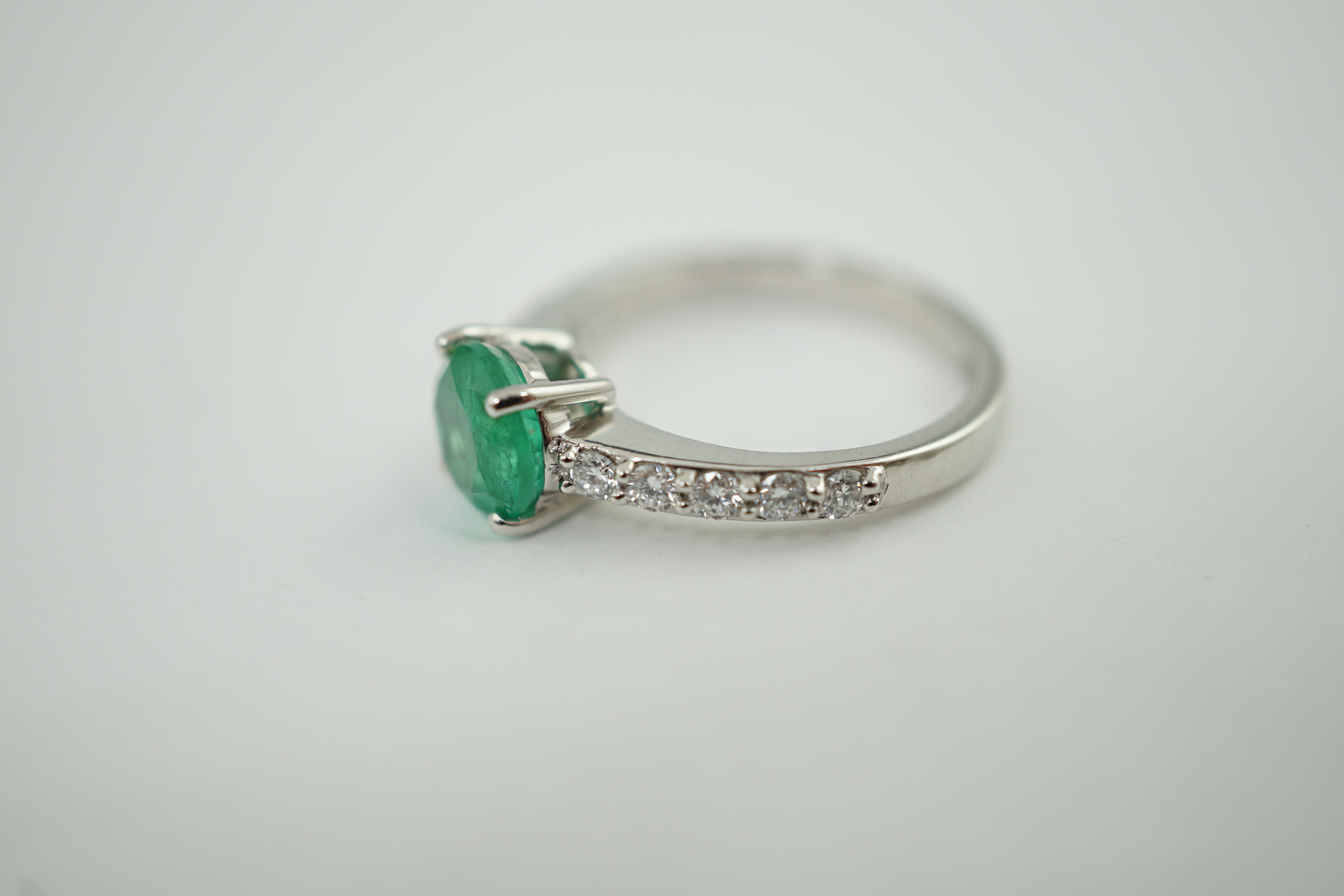 A modern Rhapsody platinum and single stone round cut emerald set ring